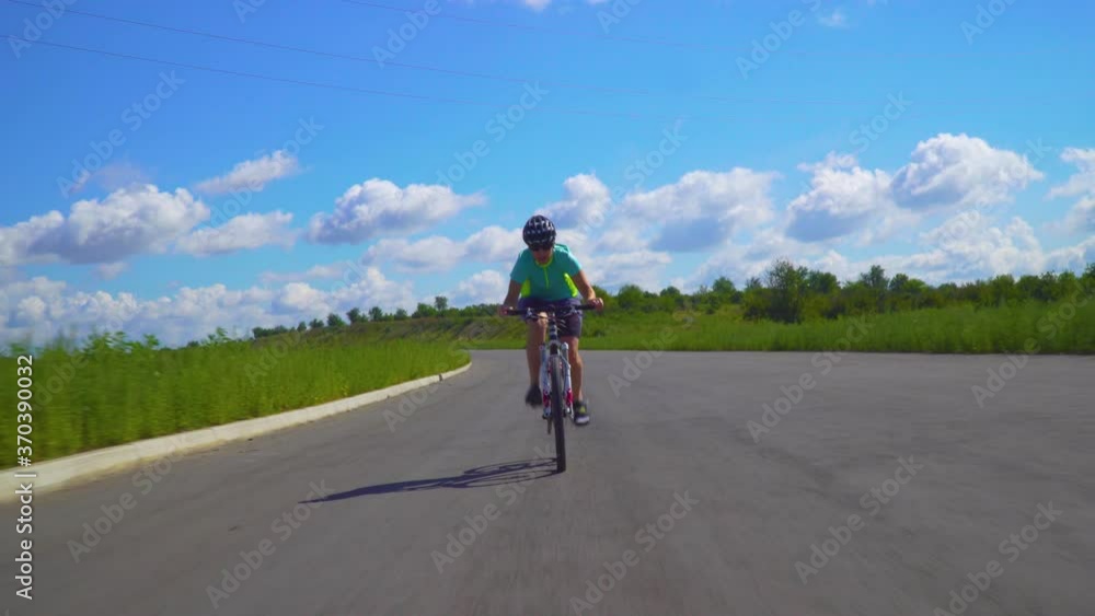 Road bike female cyclist on a Bicycle. Bicycle sport fitness athlete riding a bike on the road. Active healthy sports lifestyle of an athlete on a Bicycle on an summer day Road bike female cyclist on a Bicycle. Bicycle sport fitness athlete riding a bike on the road. Active healthy sports lifestyle of an athlete on a Bicycle on an summer day