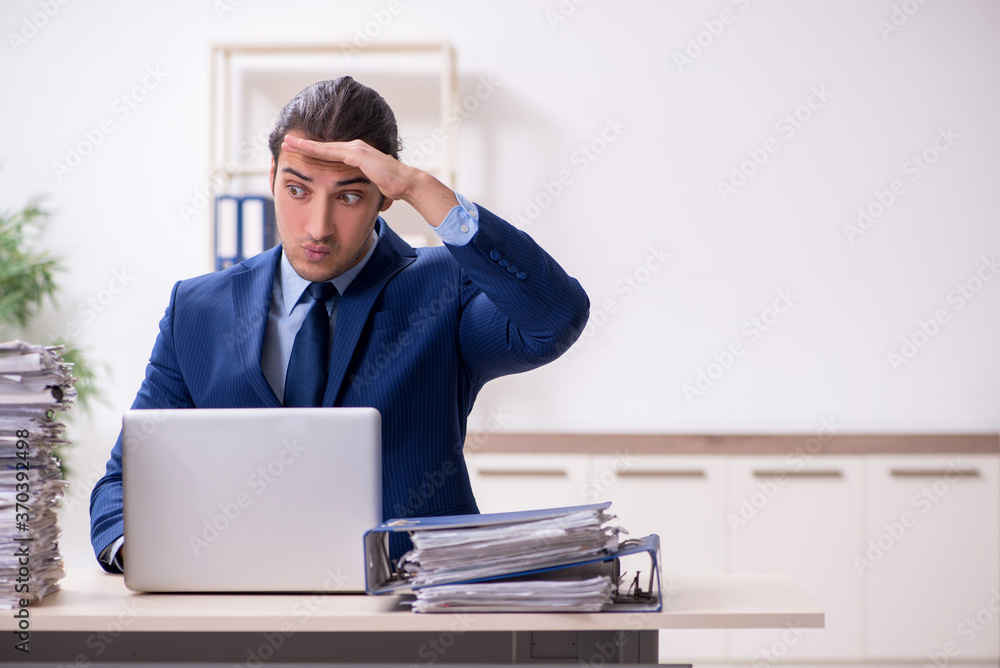 Young male employee unhappy with excessive work Young male employee unhappy with excessive work