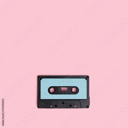 Cassette tape on a pink background. Minimal composion with copy space. photo
