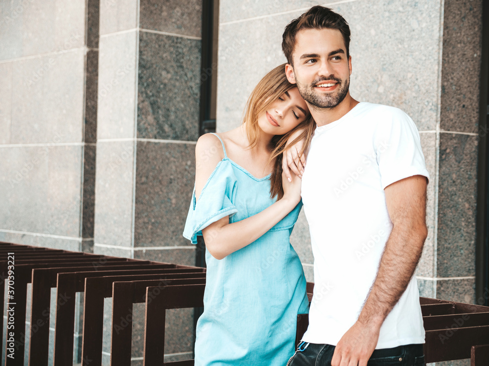 Naklejka premium Portrait of smiling beautiful woman and her handsome boyfriend. Woman in casual summer jeans dress. Happy cheerful family. Female having fun. Couple posing on the street background