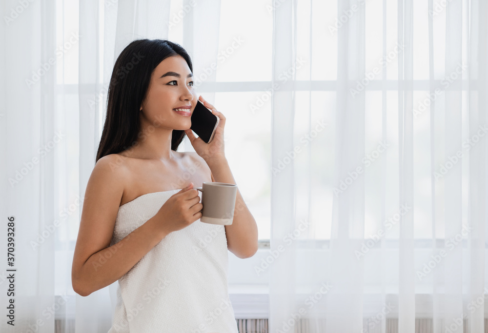 Relaxed asian girl drinking coffee and talking on phone Relaxed asian girl drinking coffee and talking on phone