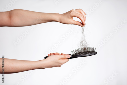 Foto Females hands clean the comb from fallen hair