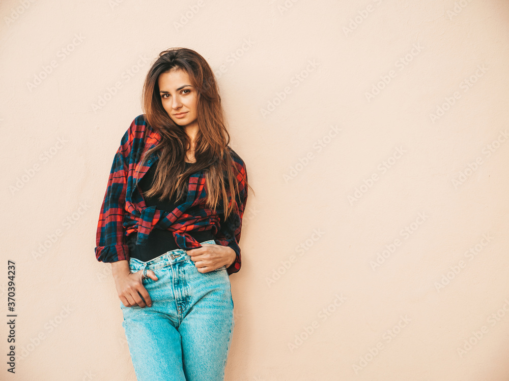 Portrait of beautiful model. Female dressed in summer hipster checkered shirt and jeans. Trendy girl posing near wall in the street. Funny and positive woman having fun outdoors Portrait of beautiful model. Female dressed in summer hipster checkered shirt and jeans. Trendy girl posing near wall in the street. Funny and positive woman having fun outdoors