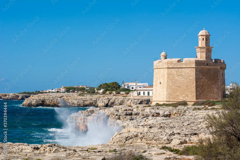 Rocky coast of west Menorca with Castell de Sant Nicolau. Ciutadella port. Menorca, Spain