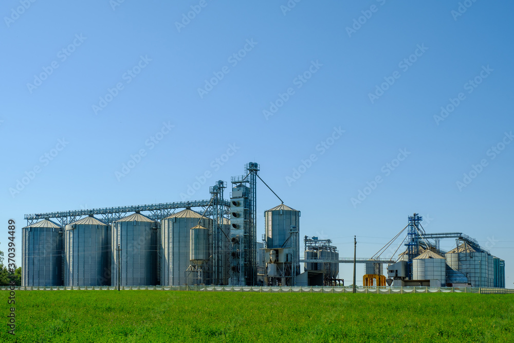 Agricultural factory with grain silos for storage and drying of grain crops. Agribusiness concept. Agricultural factory with grain silos for storage and drying of grain crops. Agribusiness concept.