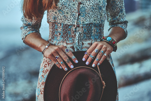 Bohemian chic gypsy woman with manicure wearing jewelry accessories and dress. Boho detail close up photo