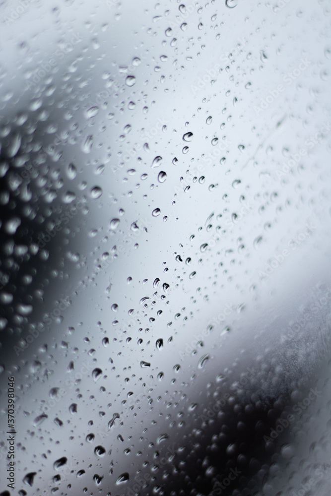 Raindrops dripping on glass out of focus with blurred background Raindrops dripping on glass out of focus with blurred background