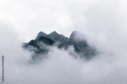 Peaks of mountains near Kranjska Gora, Slovenia, looking out of dramatic clouds, mist and fog