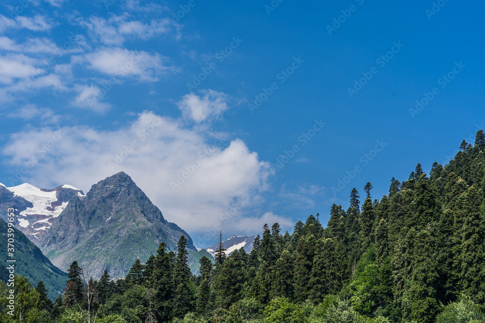 Peaks of magnificent rocks located against bright cloudy sky on sunny day in nature