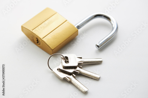 golden colored padlock with keys on a white background. private security and safety concept