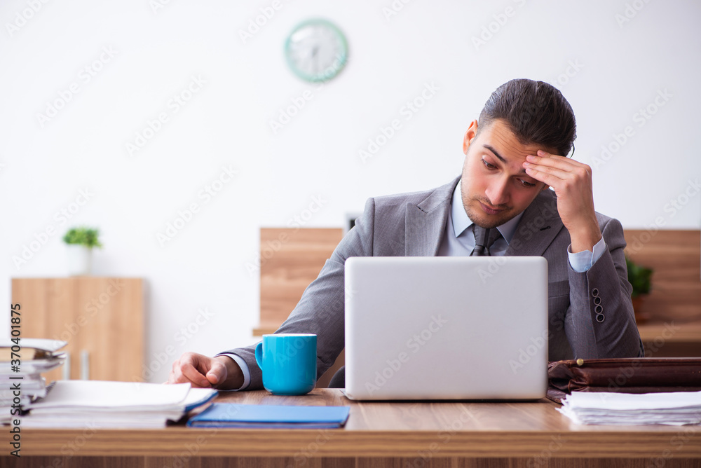 Young male employee unhappy with excessive work Young male employee unhappy with excessive work
