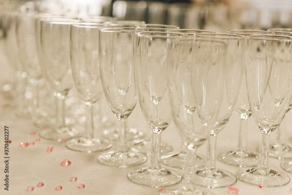 A line empty glasses of hampagne during on the party white table. Celebration concept for wedding day. A line empty glasses of hampagne during on the party white table. Celebration concept for wedding day.