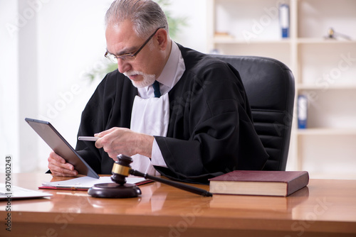 Old male judge working in courthouse