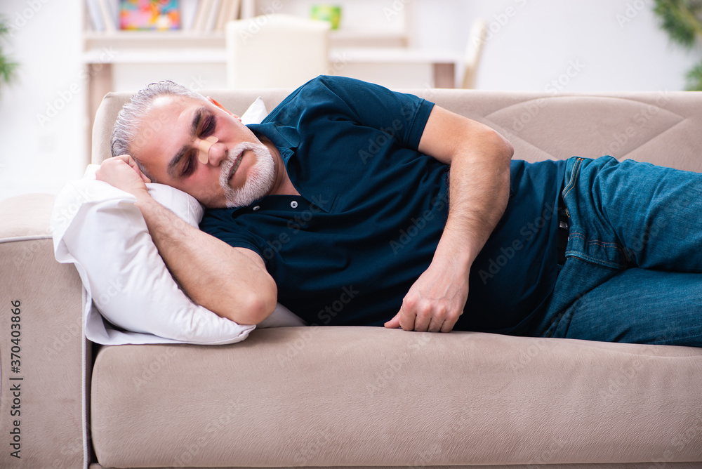 Old man with injured eyes resting at home