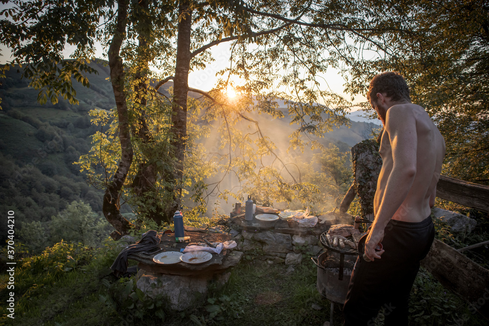 Redheaded man roasting meet on a grill Redheaded man roasting meet on a grill