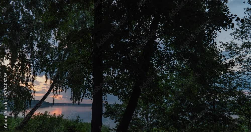 Hyperlapse on the lake shore during sunrise with dense cumulus clouds, beautiful summer landscape, camera movement along the shore between trees Hyperlapse on the lake shore during sunrise with dense cumulus clouds, beautiful summer landscape, camera movement along the shore between trees