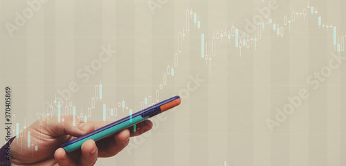 Stock quotes, stock exchange play on a mobile device. Stock candles on top of a mobile phone. photo