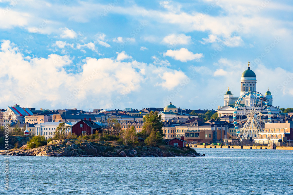Fototapeta premium Finland. Panorama of the Harbor of Helsinki. An island in the Gulf of Finland with houses on the background of Helsinki. Ferris wheel in the Harbor. The sky wheel. Cathedral Of St.Nicholas. Suurkirkko