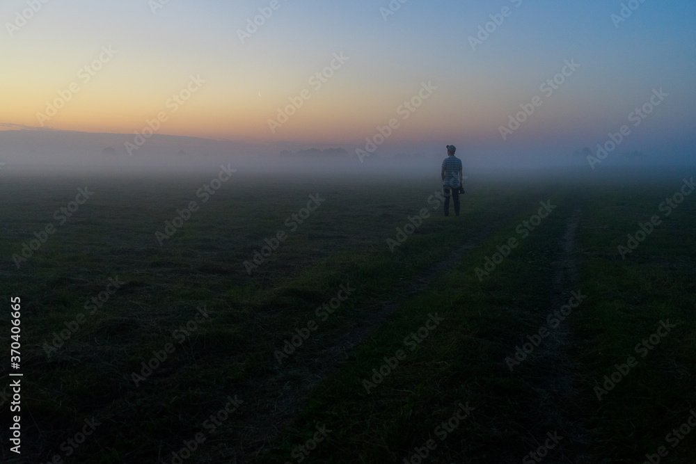 silhouette of a man walking in the fog