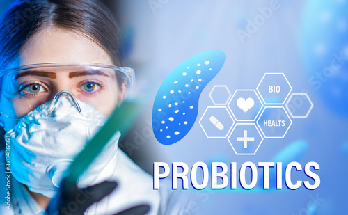 The study of the properties of probiotics. The girl is a microbiologist next to the word Probiotics. Logo of probiotics and a doctor in a protective mask.