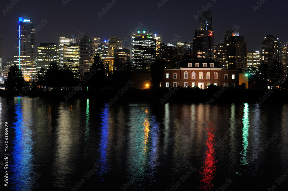 Fototapeta premium Vancouver skyline and Deadmans Island reflected in Coal Harbour from Stanley Park