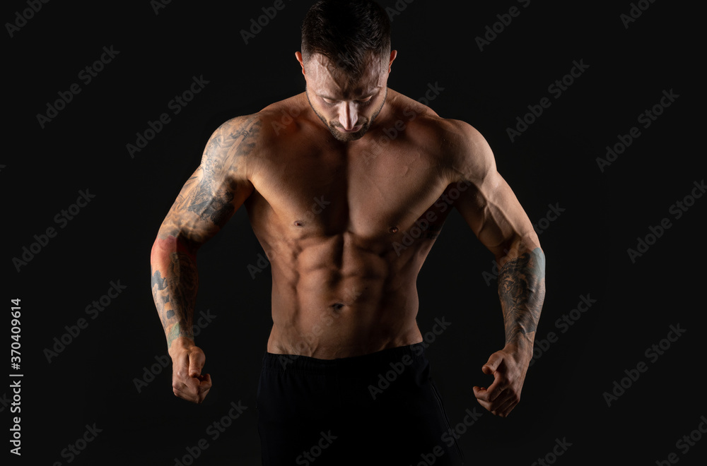 Handsome muscular male bodybuilder on a black background. Strong man. Handsome muscular male bodybuilder on a black background. Strong man.