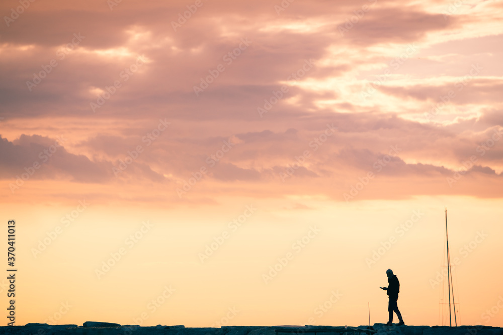 silhouette of man on pink sunset sky