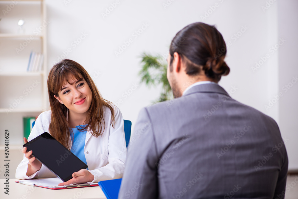 Young female doctor and sick businessman in the office Young female doctor and sick businessman in the office