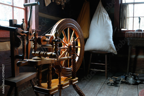 Antique wooden spinning wheel and yarn winder in the 1816 Stong house Pioneer Village Toronto photo