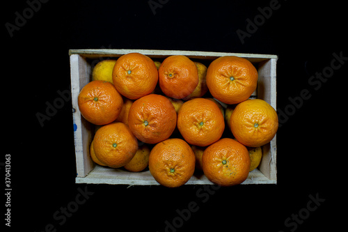 cajon de mandarina sobre fondo negro 