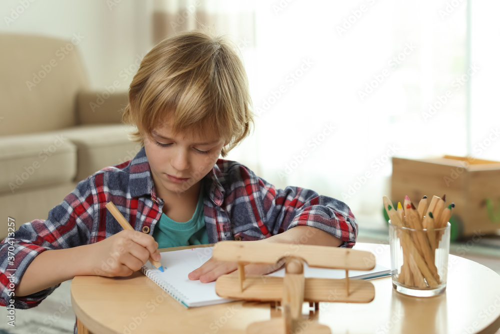 Little boy drawing at table indoors. Creative hobby Little boy drawing at table indoors. Creative hobby