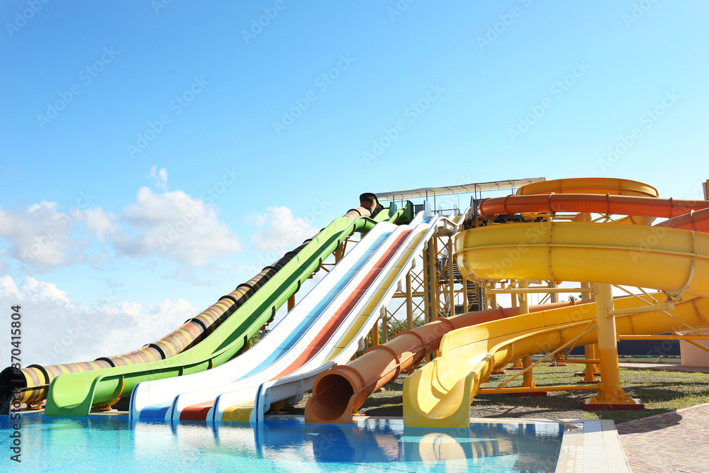 Different colorful slides in water park on sunny day Different colorful slides in water park on sunny day
