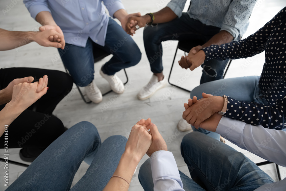 Close up diverse people sitting on chairs in circle at group training counselling session, holding hands, psychological help and treatment concept, drug or alcohol addiction rehabilitation Close up diverse people sitting on chairs in circle at group training counselling session, holding hands, psychological help and treatment concept, drug or alcohol addiction rehabilitation