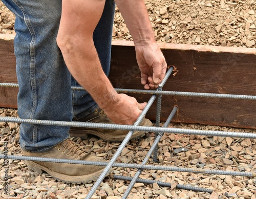 Hands tying rebar with wire construction work