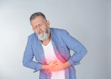 Mature man suffering from abdominal pain on light background