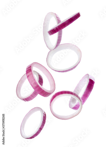 Red onion slices falling on white background