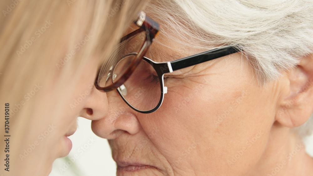 Sentimental forehead touch of young and senior woman. Close up. High quality photo Sentimental forehead touch of young and senior woman. Close up. High quality photo