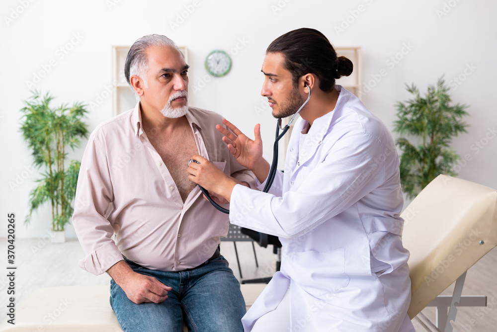 Fototapeta premium Old man visiting young male doctor cardiologist