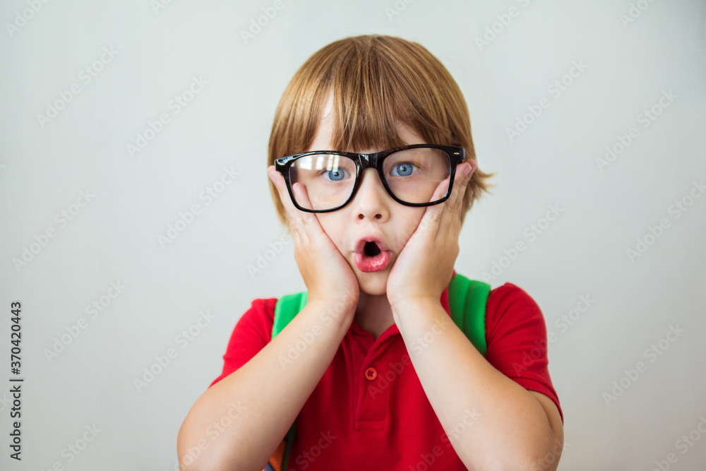 Back to school. First grade junior lifestyle teen concept. Close up studio photo portrait of cute boy surprised by something Back to school. First grade junior lifestyle teen concept. Close up studio photo portrait of cute boy surprised by something