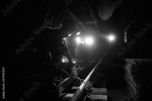 Silhouette of a working miner in a mine