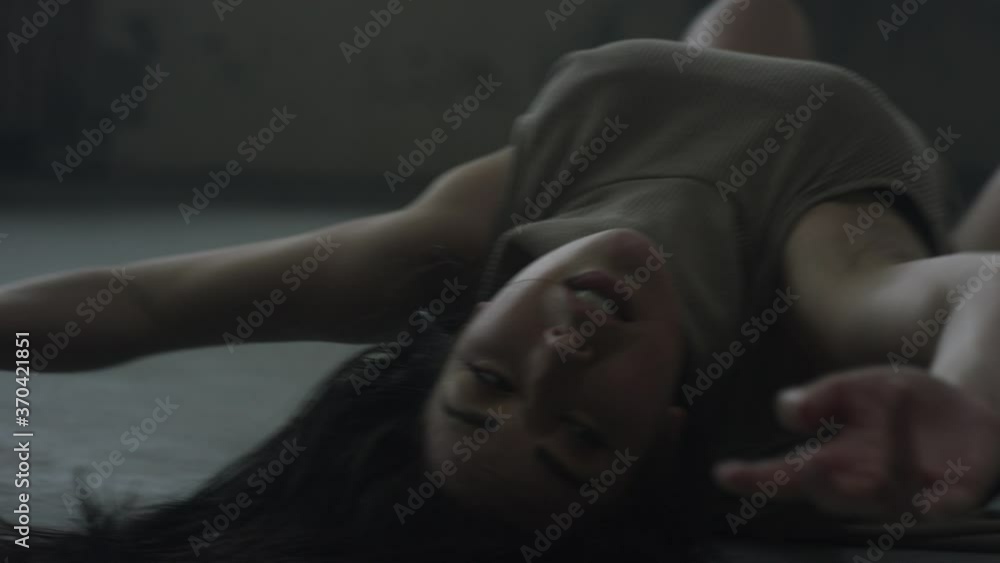 Contemporary dancer falls and rolls on the ground in industrial warehouse Contemporary dancer falls and rolls on the ground in industrial warehouse