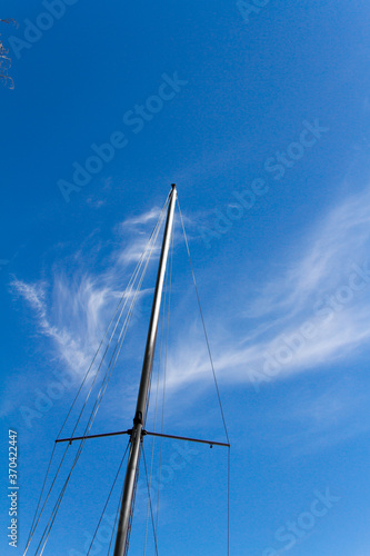 Bottom view of mast of yacht on blue sky background, selective focus