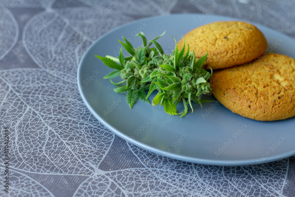Cookies with cannabis and buds of marijuana on the plate. Can of cannabis buds CBD. Medical Legal Marijuana.