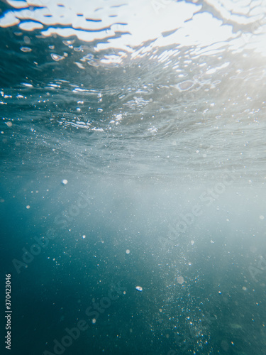 Vertical photo under the crystal clear sea with rays of light entering from above © Ivan Acedo