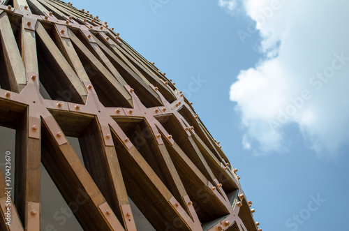 wood, architecture of a building, the details of a construction assembled with lamellar wood elements to create a vault assembled with steel brackets, screws and bolts. photo