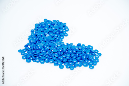 blue pills are piled up on a white background