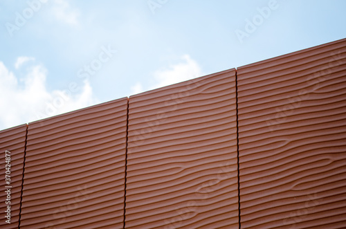 Background perspectives, which reflect the facade of a building with prefabricated panels of red concrete that recalls the silhouettes such as sand dunes in the desert smoothed by the wind, of the sea photo
