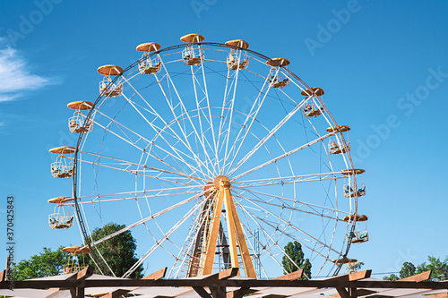 Ferris Wheel and Carousel Top colorful fair rides against blue sky. Vacation concept