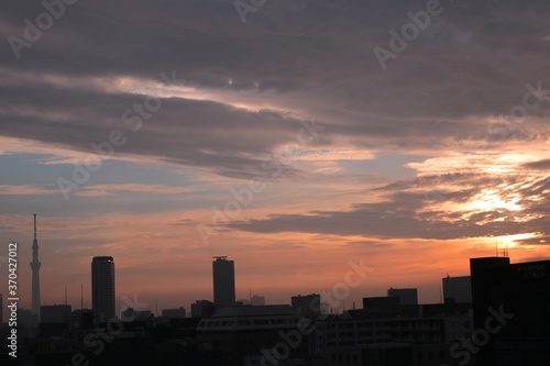 東京の街の夜明けと建物のシルエット茜色に染まる空