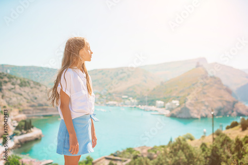 Little girl on top of a mountain enjoying valley view